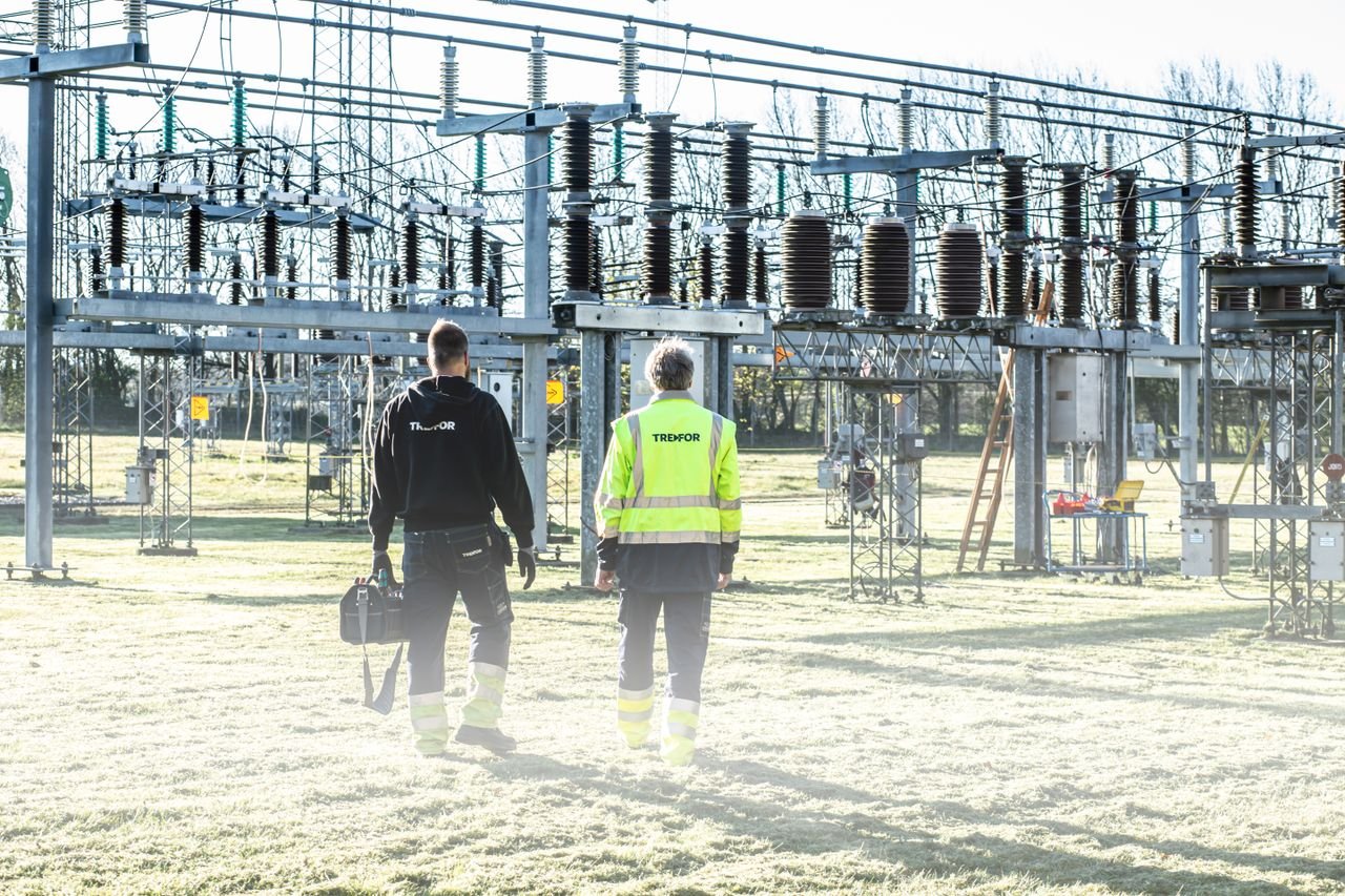 Ingeniería técnica, licencias y subvenciones | ALD Serveis d'Enginyeria Two workers inspect an outdoor electrical substation, emphasizing safety and maintenance.
