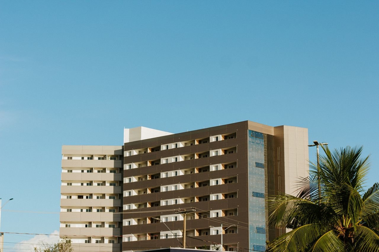 Contemporary apartment building in Palmas, Brazil with clear blue skies and palm trees.